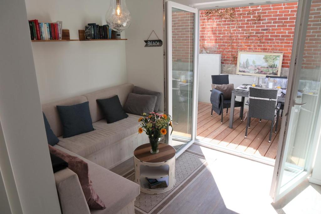 a living room with a couch and a table at Hafenperle am Suhrenpohl in Heiligenhafen