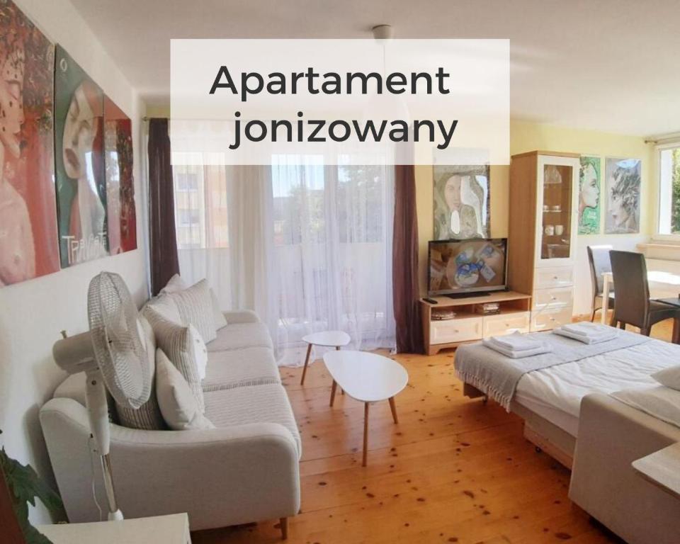 ein Wohnzimmer mit einem Sofa und einem Tisch in der Unterkunft SunRoom Szczecin in Stettin