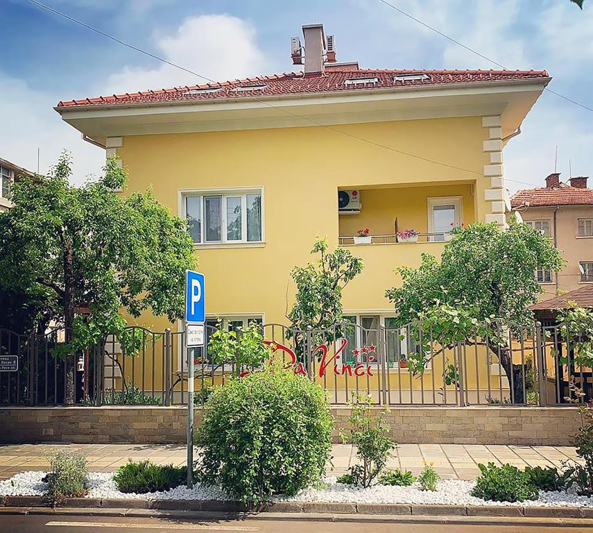 ein gelbes Haus mit einem Parkschild davor in der Unterkunft Da Vinci Guesthouse in Varshets