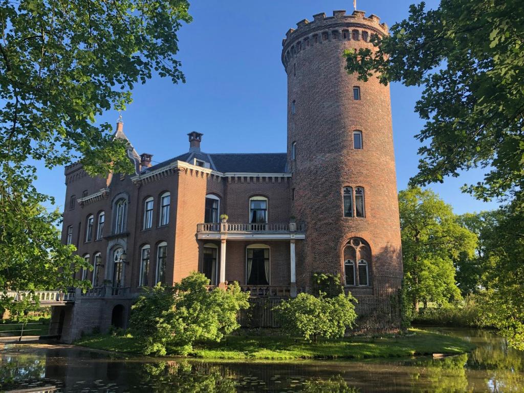 un vieux château avec une tour sur l'eau dans l'établissement Kasteel Sterkenburg, à Driebergen