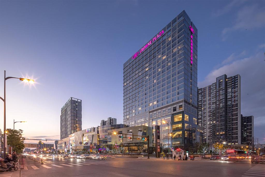 a tall building with a sign on it in a city at Crowne Plaza Kunshan, an IHG Hotel in Kunshan