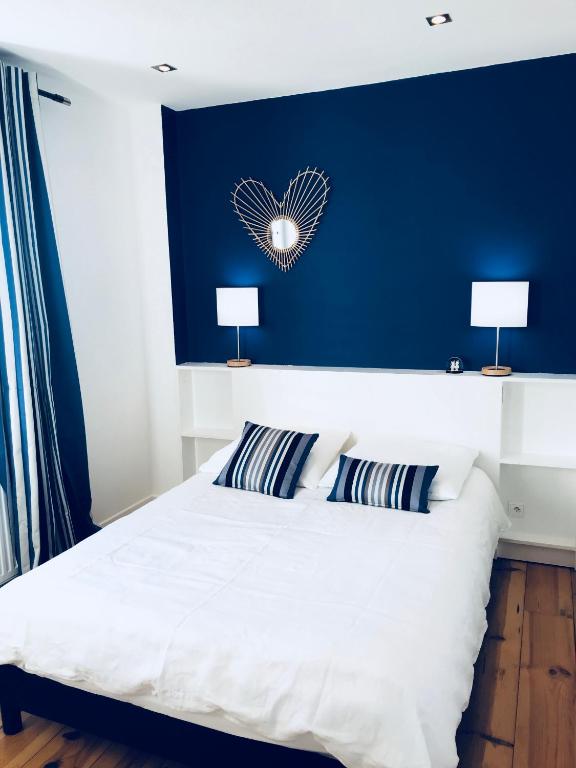 une chambre avec un grand lit blanc avec deux lampes dans l'établissement Appartement Plage Calme Centre 4personnes St Jean de Luz, à Saint-Jean-de-Luz