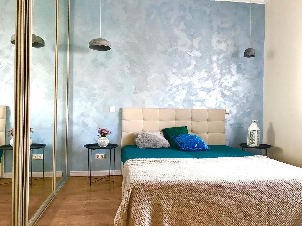 a bedroom with a bed with a blue wall at VILLA FLORANCE apartments with terraces & parking in Ventspils