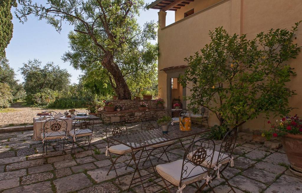 a patio with a table and chairs and a tree at Villa Il Paradisino in Sesto Fiorentino