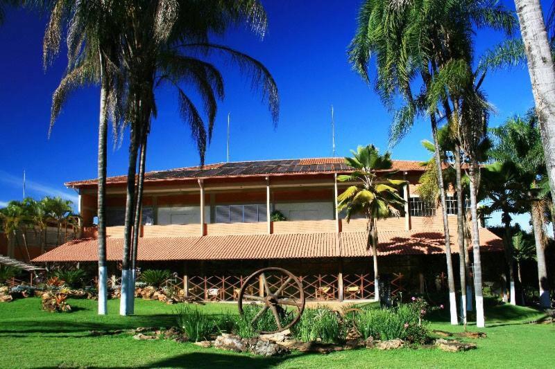 una casa con palmeras delante en Estancia Park Hotel, en Anápolis