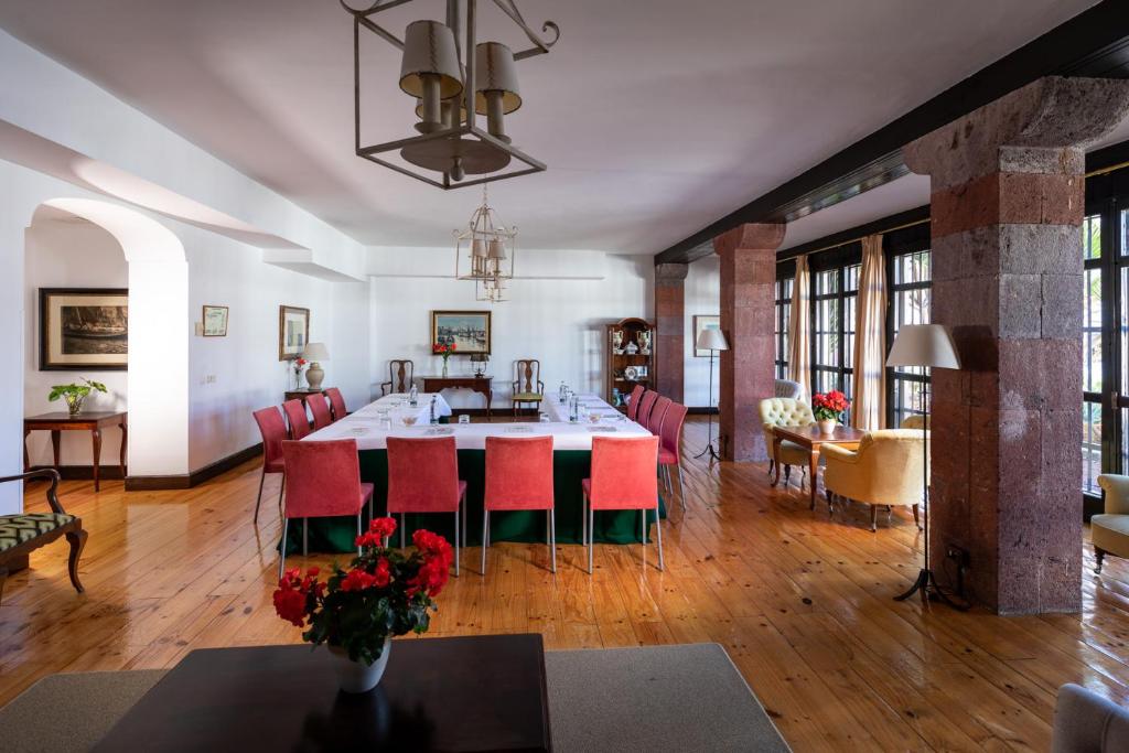 a dining room with a table and red chairs at Parador de La Gomera in San Sebastián de la Gomera