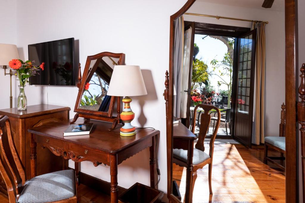 a room with a table with a lamp and a mirror at Parador de La Gomera in San Sebastián de la Gomera