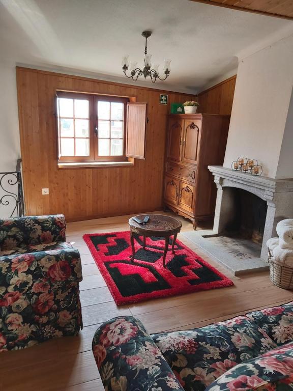 a living room with a table and a fireplace at Casa da Souropires in Pinhel