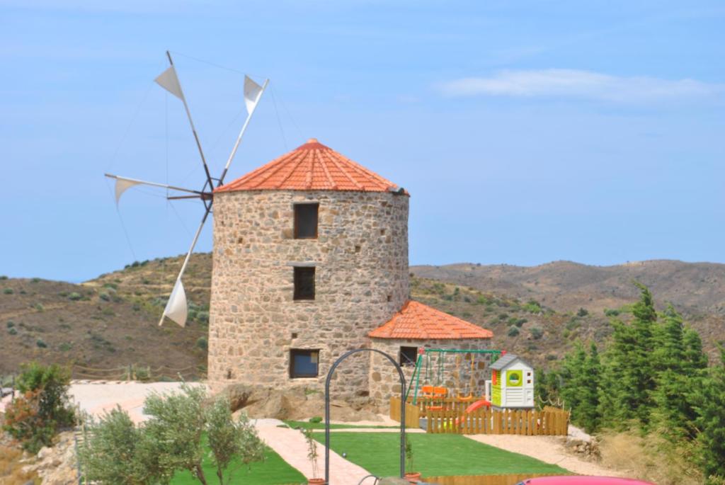 un edificio con mulino a vento in cortile di Ανεμόμυλος του Οδυσσέα a Volissos