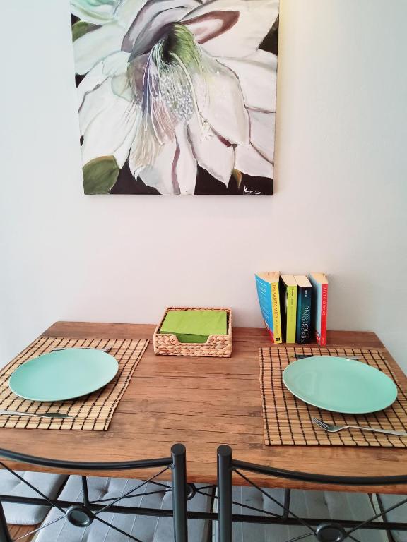 a wooden table with two chairs and books on it at Nefeli in Livadi