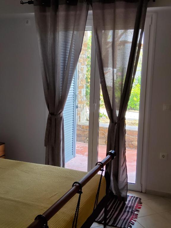 a bedroom with a bed and a large window at Nefeli in Livadi