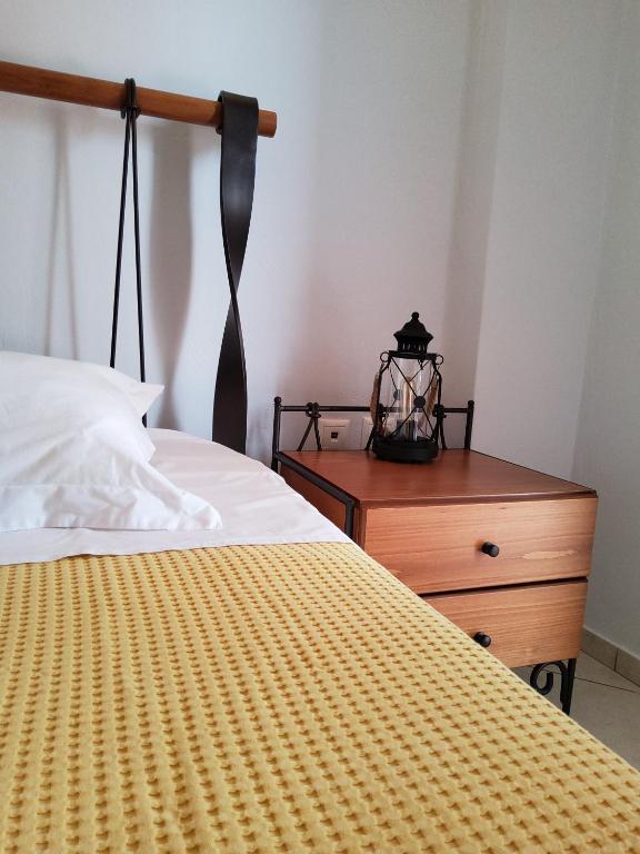 a bedroom with a bed and a wooden dresser at Nefeli in Livadi