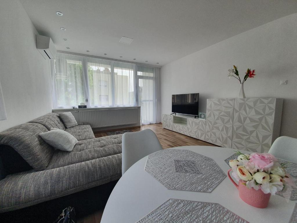 salon z kanapą i stołem w obiekcie Mátrix apartman w mieście Békéscsaba