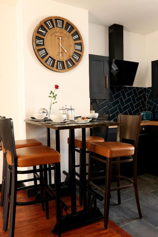 une table avec des chaises et une grande horloge sur le mur dans l'établissement La Tour notre Dame, à Boulogne-sur-Mer