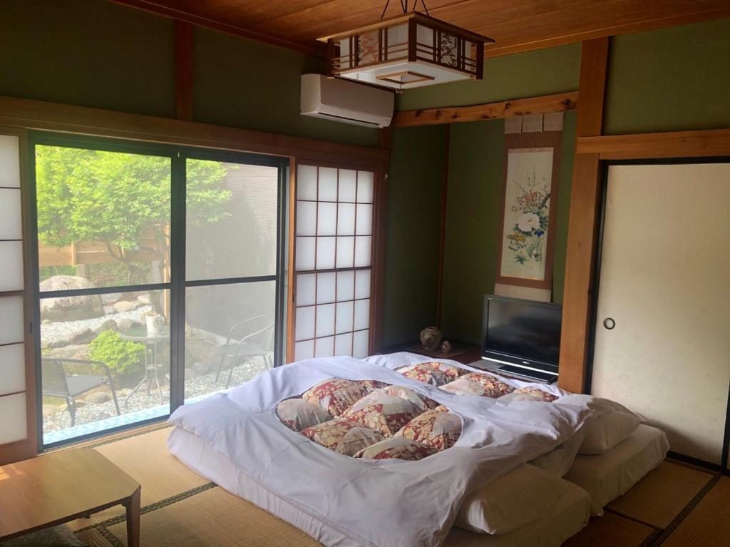 a large bed in a room with a large window at Stay Nikko Guesthouse in Nikko