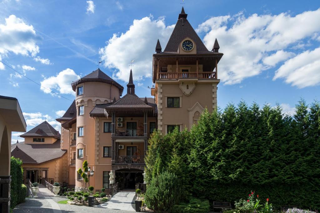 a building with a tower with a clock on it at Hotel Resort&Spa Kamelot in Kamenitsa