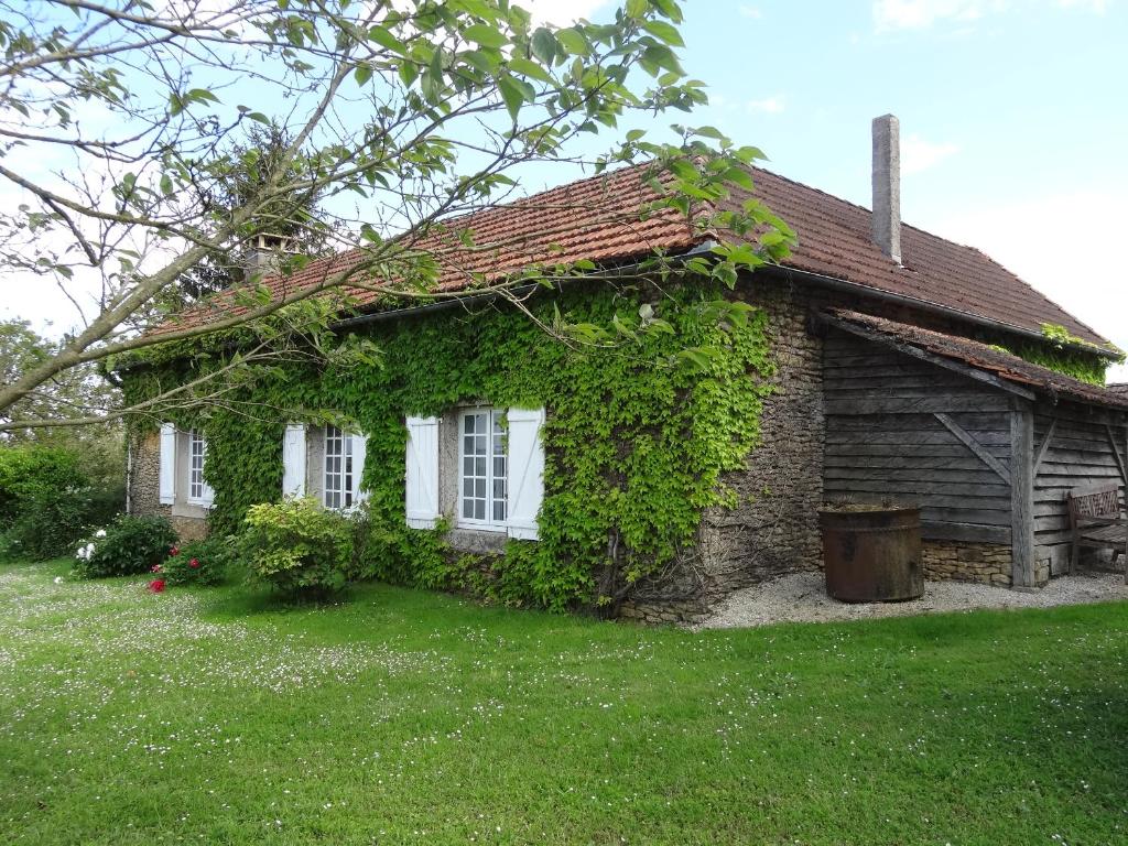 Una pequeña casa con hiedra a un lado. en "Castel" en Saint-Amand-de-Coly