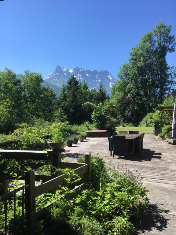 a patio with tables and chairs and mountains in the background at Chalet Ingas in Troistorrents