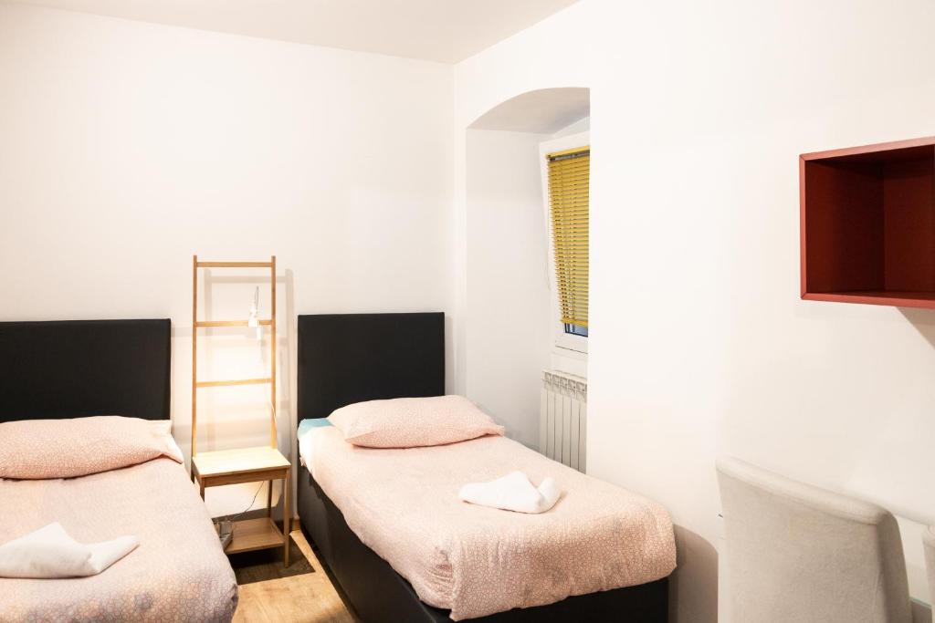 ein kleines Zimmer mit 2 Betten und einem Spiegel in der Unterkunft Apartments Museum in Koper