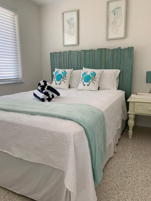Schlafzimmer mit einem Bett mit einem grünen Kopfteil in der Unterkunft Ocean Eleven Suites in New Smyrna Beach