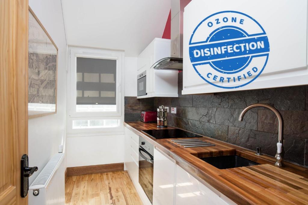 a kitchen with a sink and a sign on the wall at Castle Vista, Grassmarket Apartment in Edinburgh