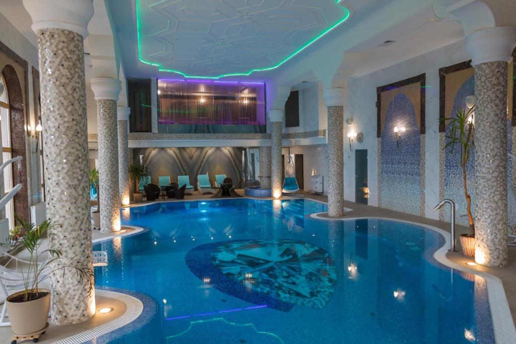 a large swimming pool in a hotel with a ceiling at Kamelot in Kamenitsa