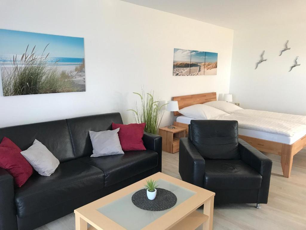 ein Wohnzimmer mit einem Sofa und einem Bett in der Unterkunft Steiner Strandappartements Appartement 101 Seeseite in Stein