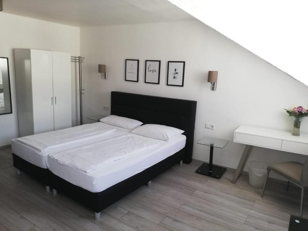 a bedroom with a large white bed and a desk at Hotel Luisenhof in Wiesbaden