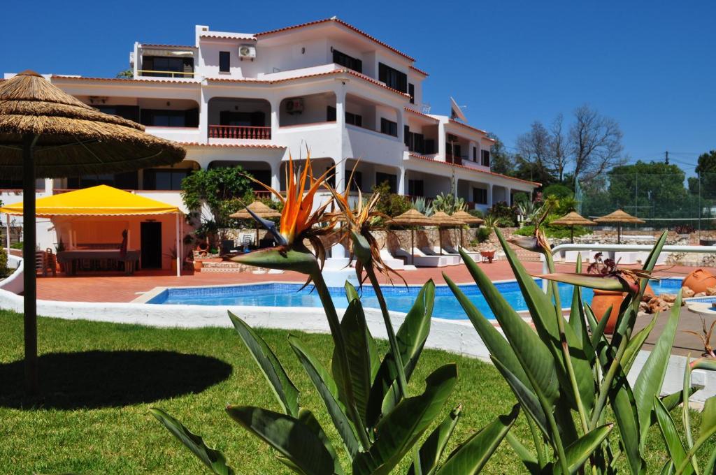 um grande edifício com uma piscina ao lado de um resort em Casa Areias Boutique Apartments em Albufeira