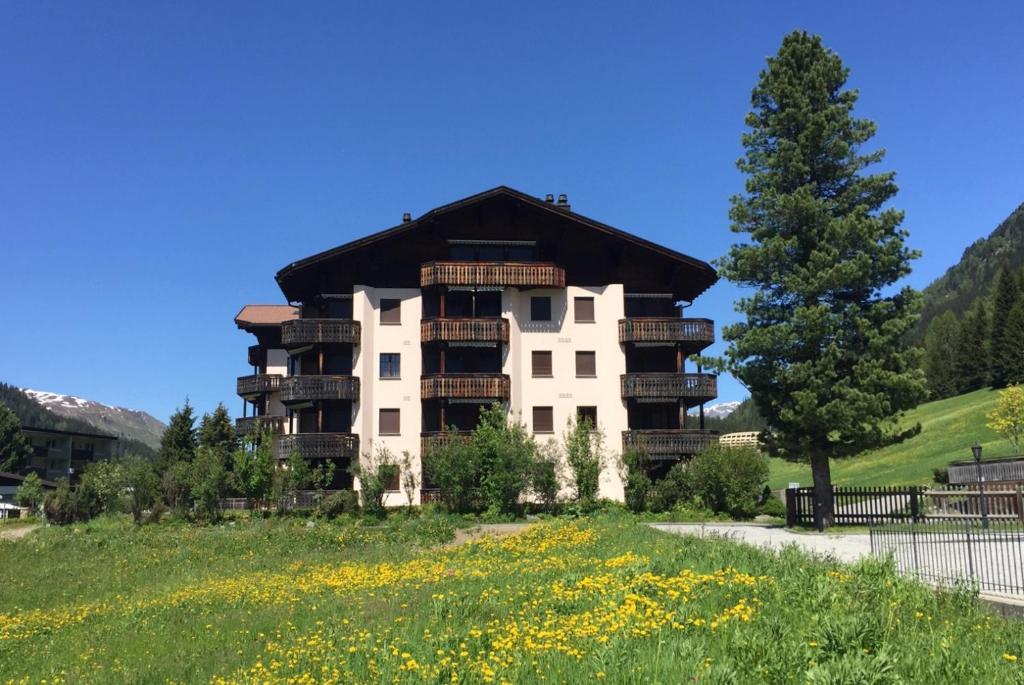an apartment building with balconies and a field of flowers at 2-Zimmer Ferienwohnung Bünda in Davos