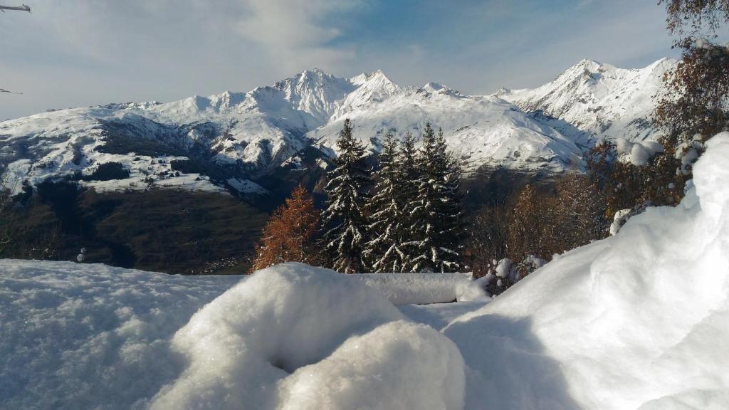 uma pilha de neve com uma montanha ao fundo em les 3 marmottes - Les Arolles em Bourg-Saint-Maurice