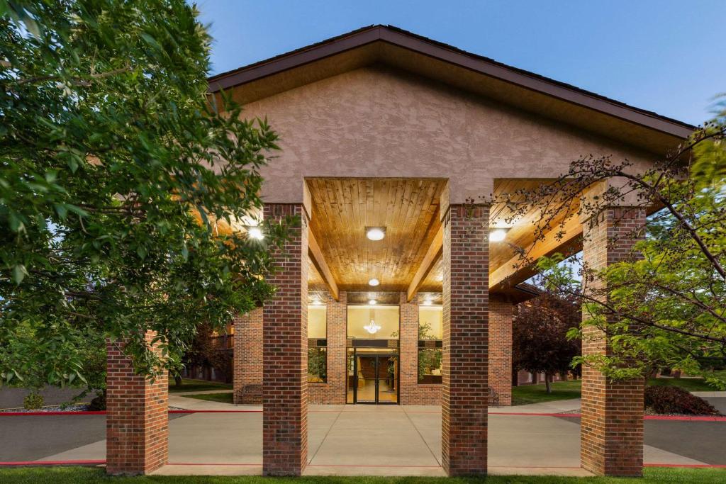 a large brick building with trees in front of it at Baymont by Wyndham Cortez in Cortez