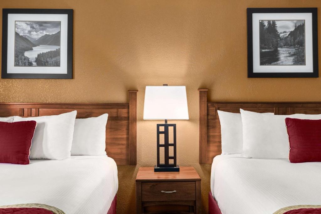 a hotel room with two beds and a lamp at Baymont by Wyndham Cortez in Cortez