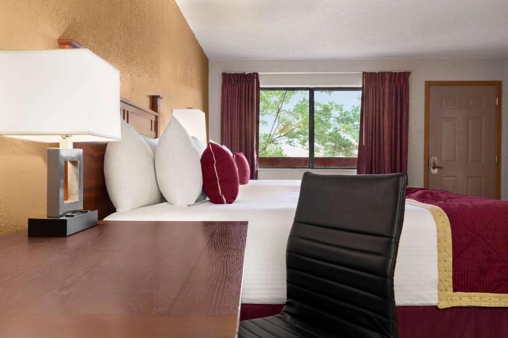 a hotel room with a bed and a window at Baymont by Wyndham Cortez in Cortez