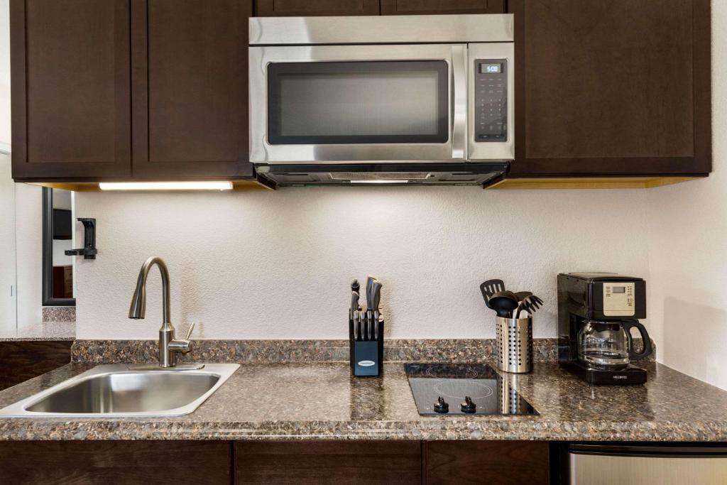 a kitchen with a sink and a microwave at Baymont by Wyndham Cortez in Cortez