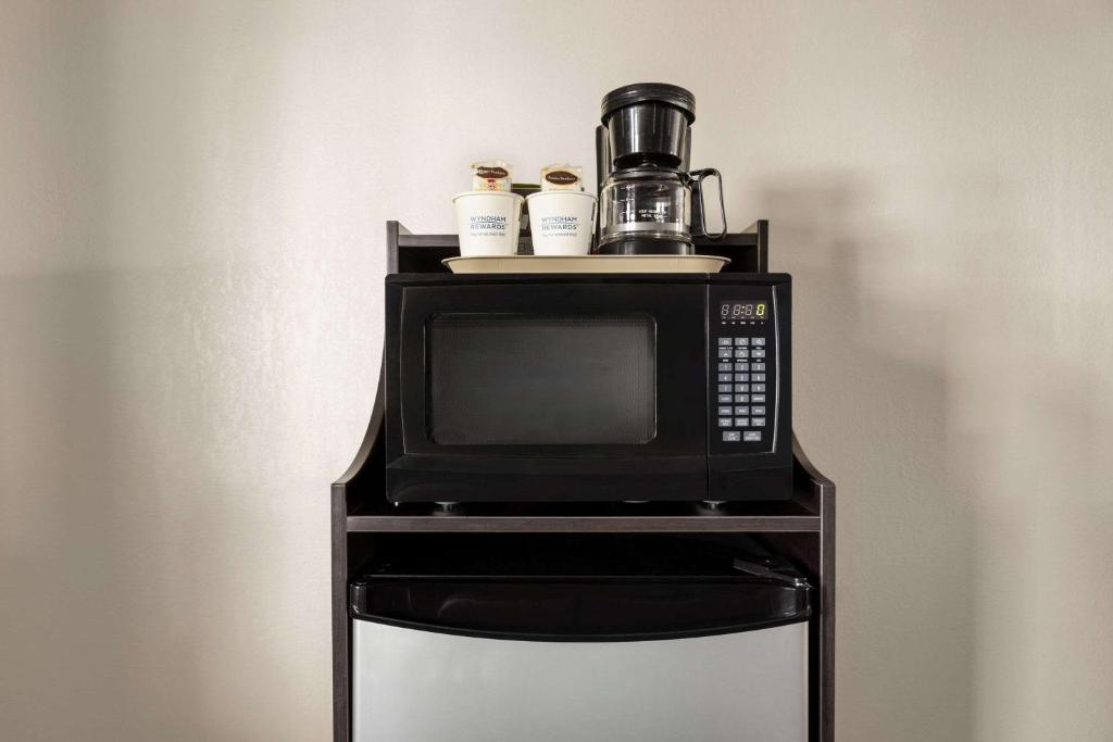 a microwave with a coffee maker on top of it at Baymont by Wyndham Cortez in Cortez