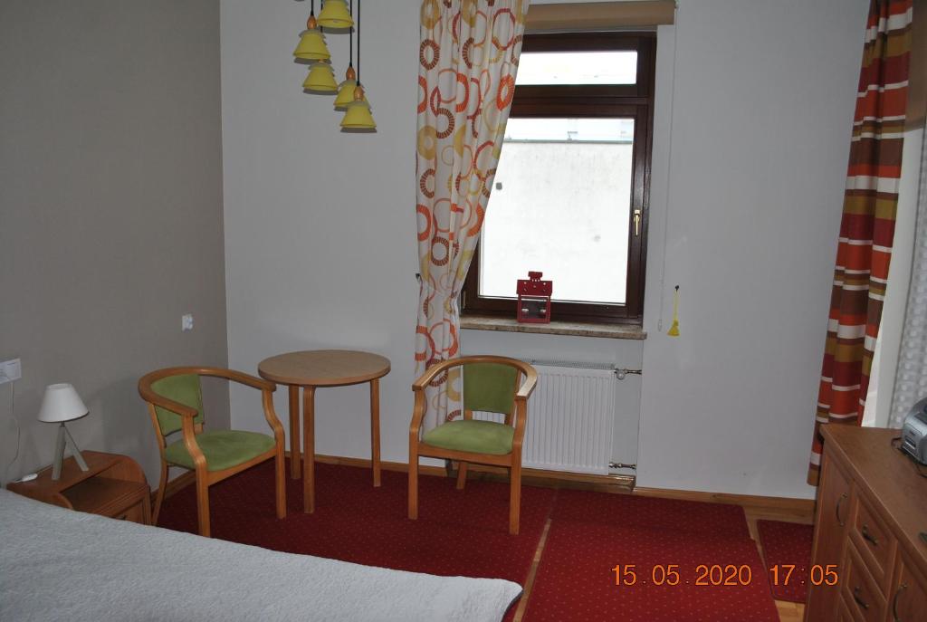 um quarto com uma mesa, 2 cadeiras e uma janela em Pokoje z łazienkami em Kolobrzeg