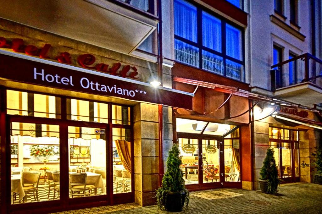Hotel Ottaviano entrance at night, glass doors revealing lit dining area and signage above.