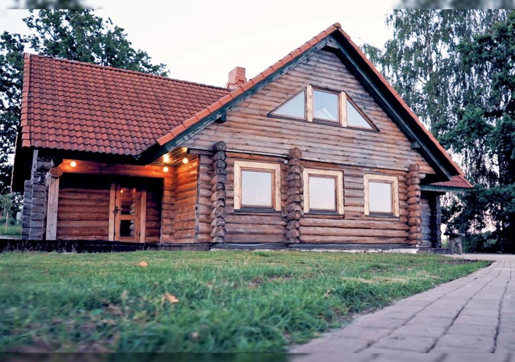 una casa de madera con porche en un campo de césped en Guest house Lankalni, 