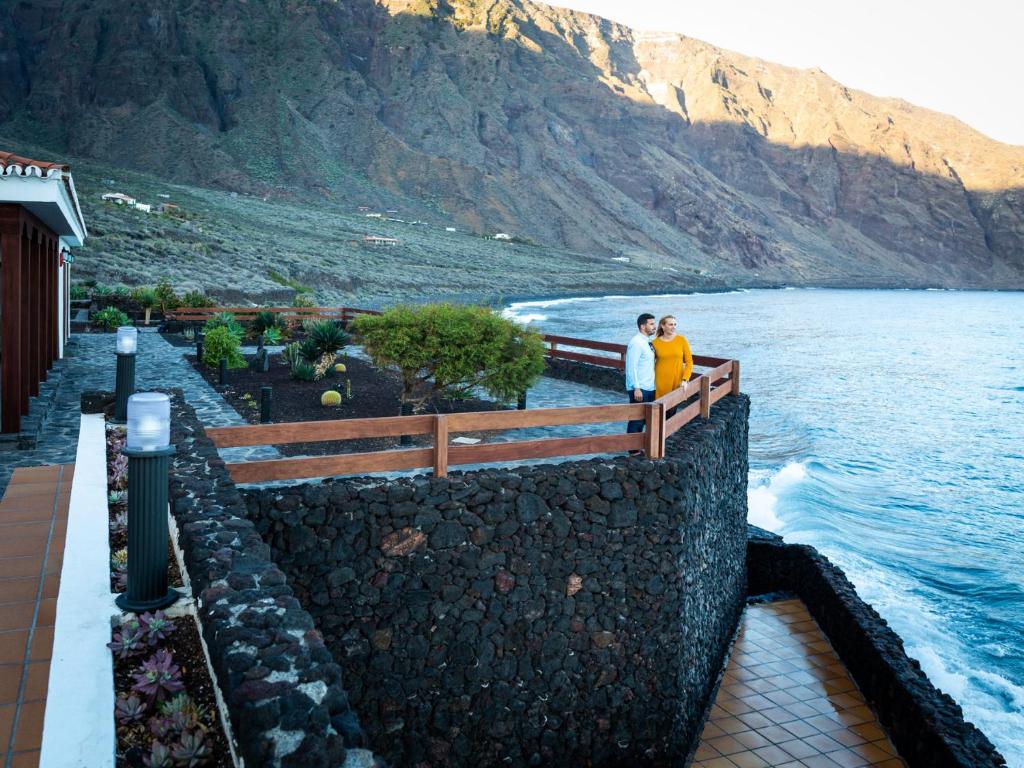 two people standing on a bridge over a body of water at Parador de El Hierro in Las Casas