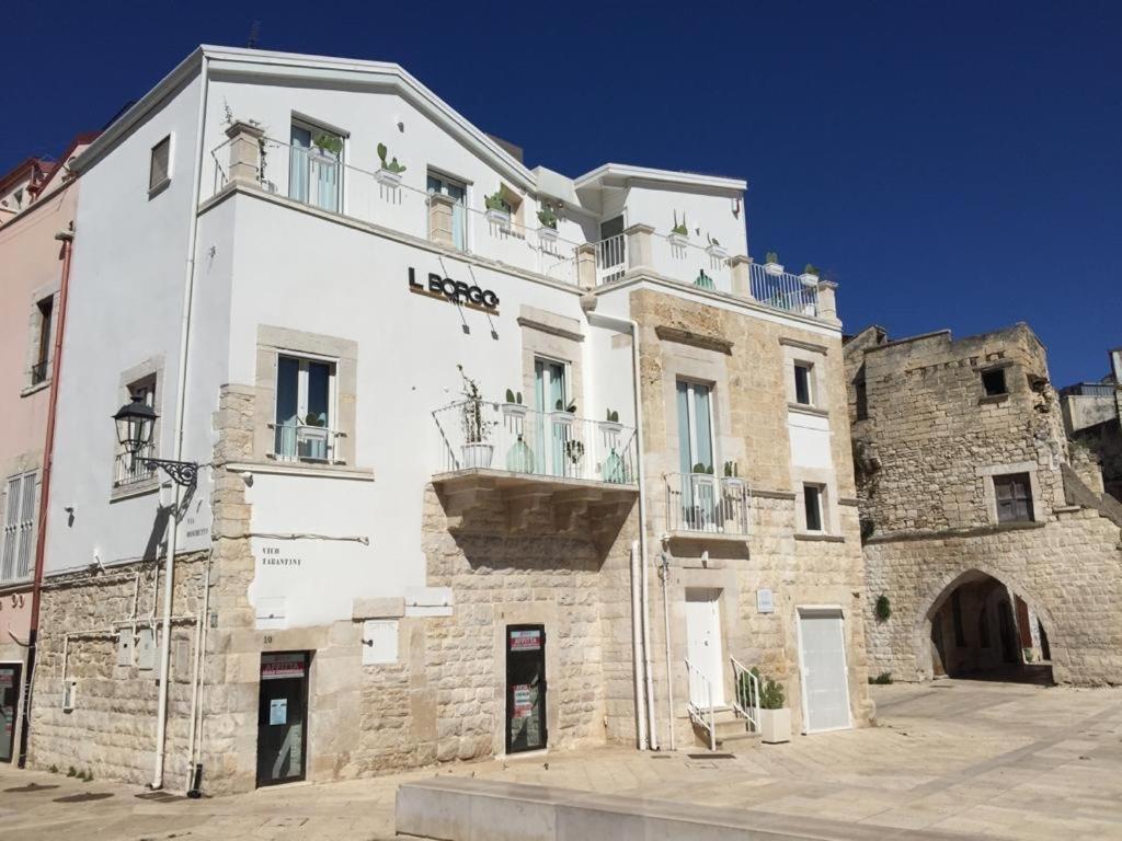 un gran edificio blanco frente a un edificio de piedra en Il Borgo en Corato