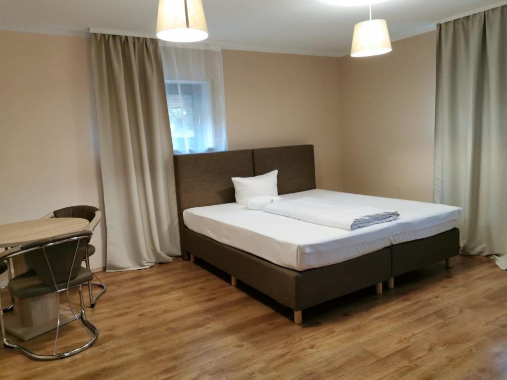 a bedroom with a bed and a desk in it at Hotel-Residenz Oberurseler Hof in Oberursel