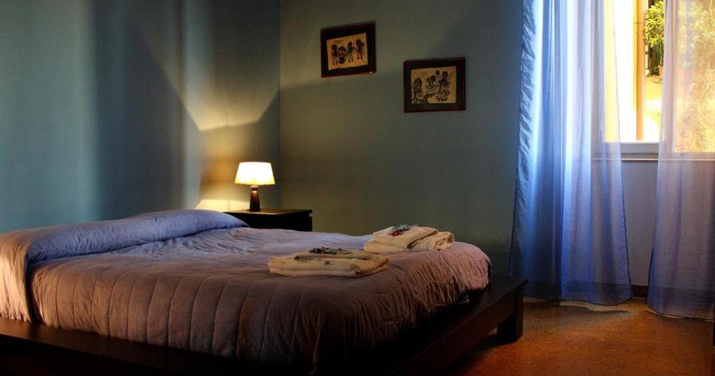 una camera da letto con un letto e asciugamani di A Due Passi Dal Treno a Pisa
