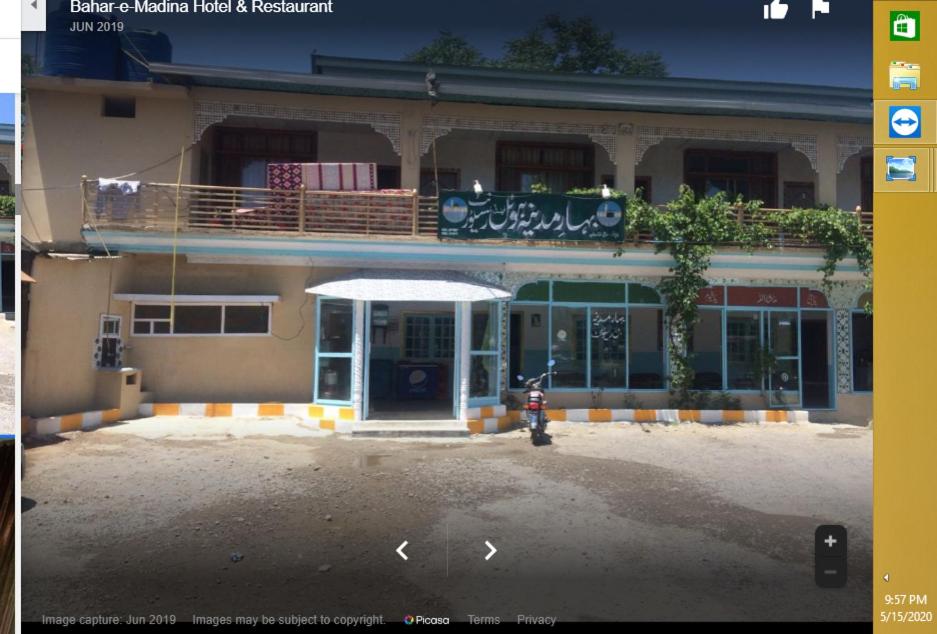 Bahar E Madina Mansehra في Chitta Batta: مبنى به دراجة نارية متوقفة أمامه