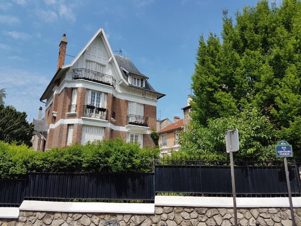 une grande maison avec une clôture devant elle dans l'établissement La Romantique, à Paris