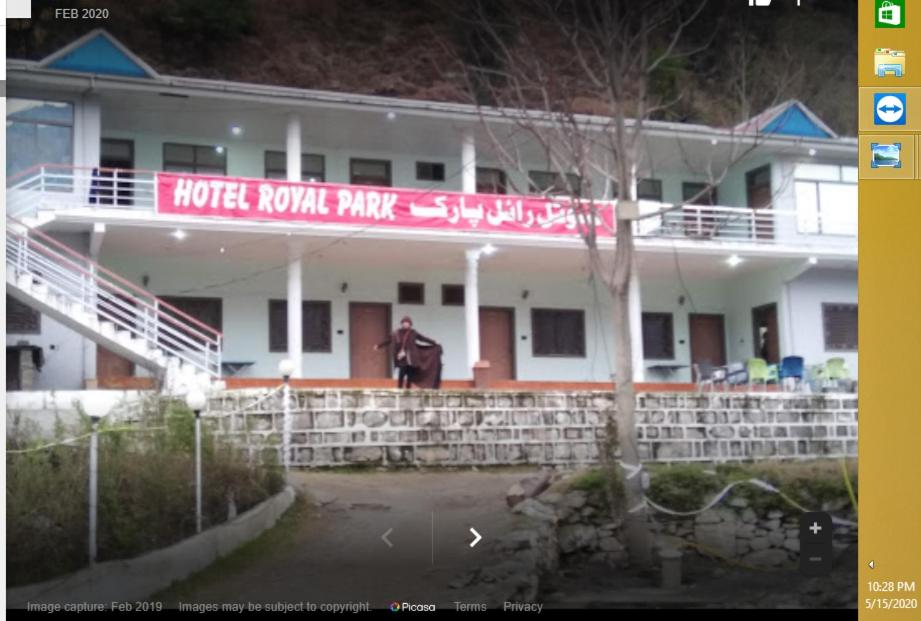 a man standing in front of a white building at Hotel Royal Park in Hassa