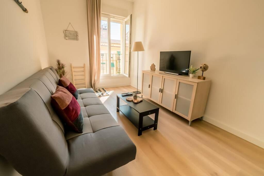een woonkamer met een bank en een televisie bij TGH/ Malagueta paradise II in Málaga