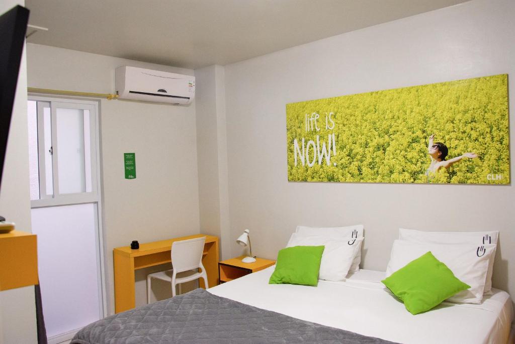 1 dormitorio con 1 cama y una pintura verde en la pared en Che Lagarto Hostel Ipanema en Río de Janeiro