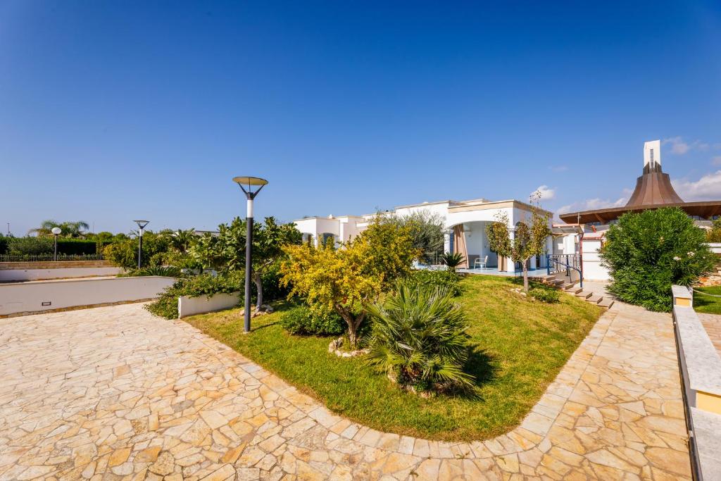 a resort with a garden with trees and plants at Mare Villas Pescoluse in Marina di Pescoluse