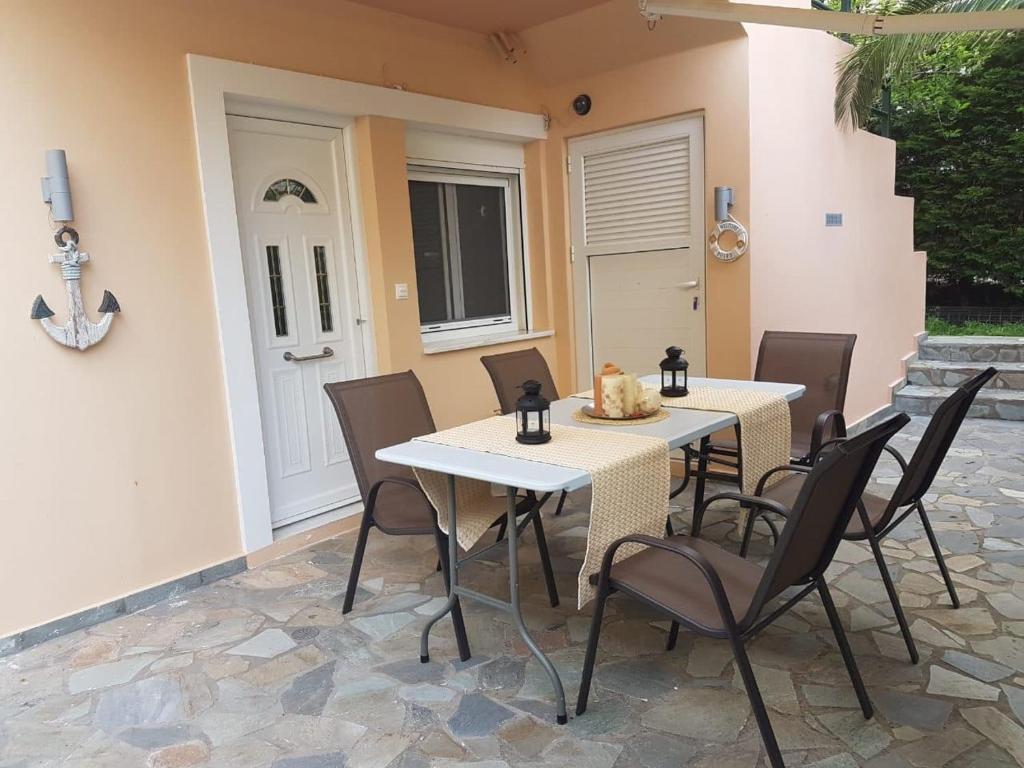 een patio met 2 tafels en stoelen en een deur bij cozy apartment nafpaktos in Nafpaktos